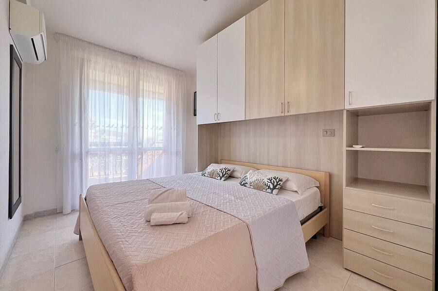 Camera da letto con armadio in legno e cuscini corallo